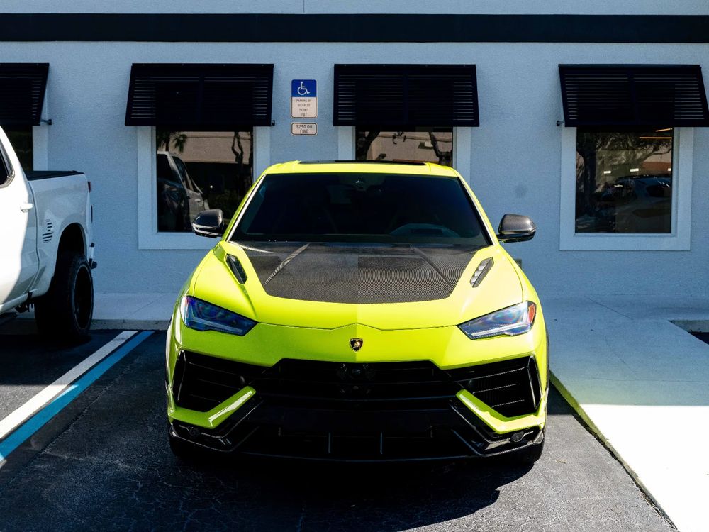 Lime green Lamborghini Urus under the hexagon lights in the Detailers of Naples bay